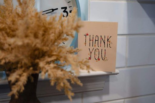 Fireplace mantel with fall-themed thank you card sitting next to a clock