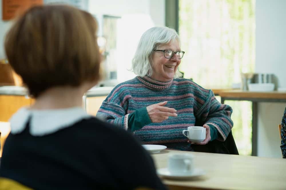 Older woman with white hear smiling with friends